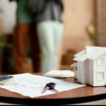 Documentos e chave ao lado de casa em miniatura