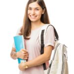 Mulher estudante sorrindo com caderno e mochila em fundo branco