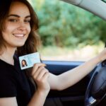 Mulher sorrindo ao volante com CNH