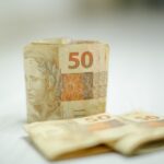 Notas de cinquenta reais sobre mesa de madeira