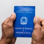 Pessoa idosa segurando carteira de trabalho