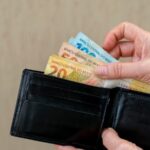 Pessoa tirando notas de dinheiro da carteira