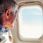 Senhor idoso olhando pela janela de avião