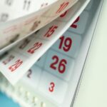 Zoom em pessoa levantando páginas de calendário