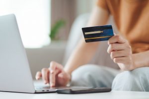 Mulher fazendo compra on-line com cartão de crédito